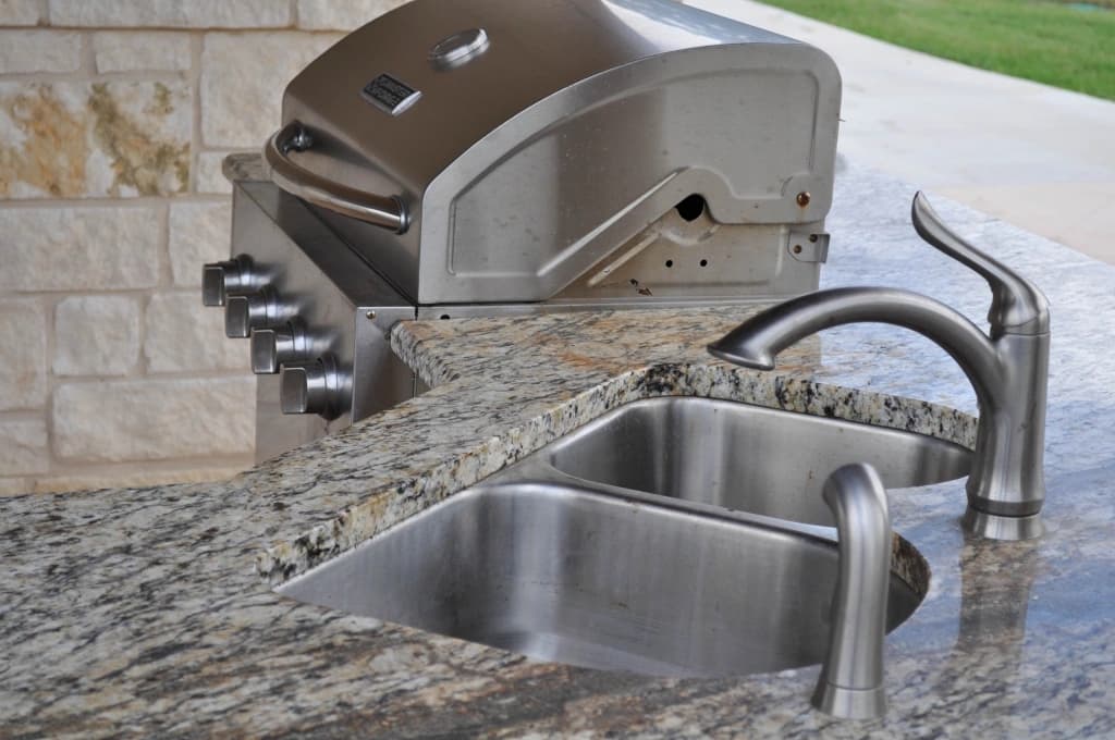 The casita's outdoor kitchen with built-in stainless grill and double sink set in granite