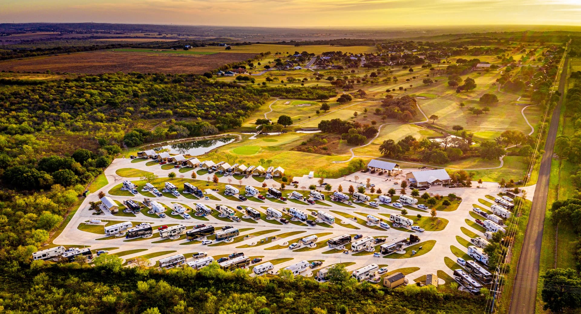 Golden-hour aerial of the resort grounds and adjacent golf course